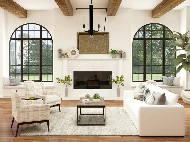 Bright staged living room with arched windows, white sofas, and a fireplace beneath wood beams