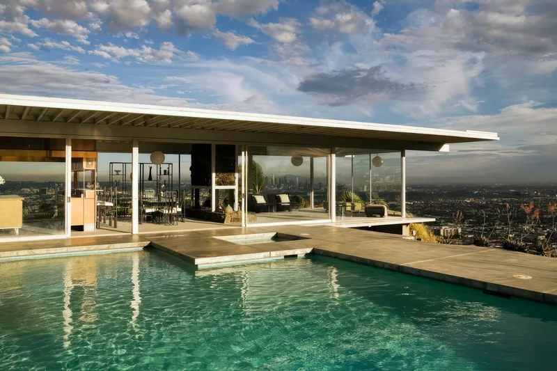 Mid-century modern house with a cantilevered flat roof over a pool and city view