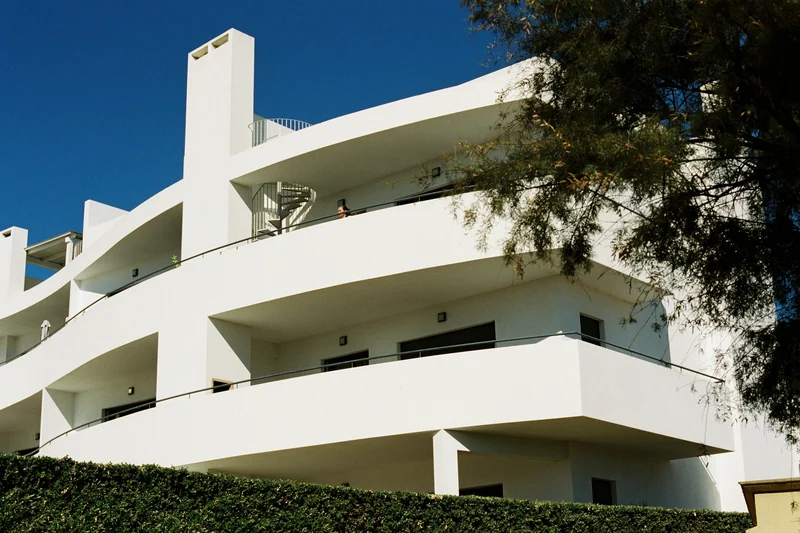 White modern condominium building with curved wraparound balconies
